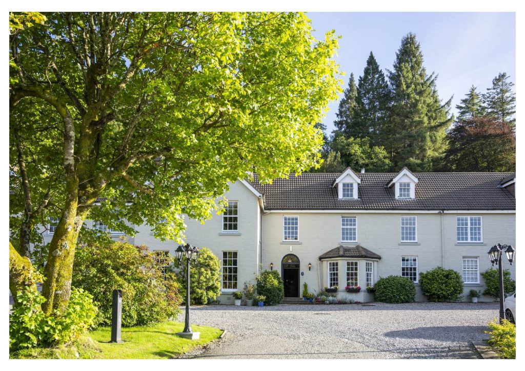 Image of a white hotel building with gardens