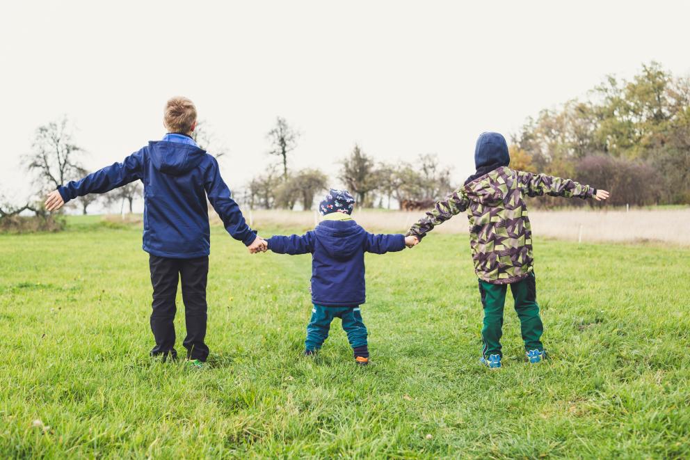 A picture of three children holding hands