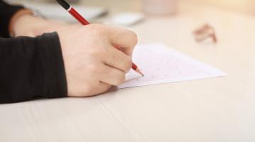 School pupil writing on sheet of paper