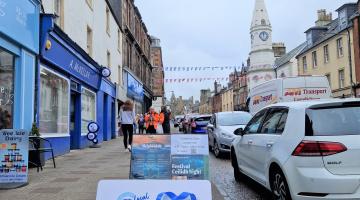 Images shows Campbeltown High Street shops to the left of the picture. Bunting flies above the street and in the foreground is the Argyll and Bute gift card