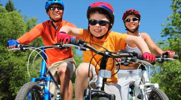 Images shows two adults and a young child on bikes 