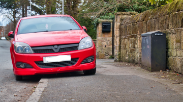 red car parked on a pavement