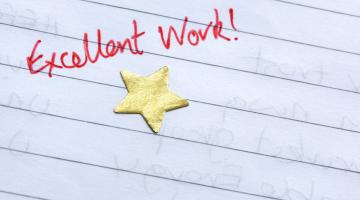 Images shows a gold star on notepaper with the words excellent work