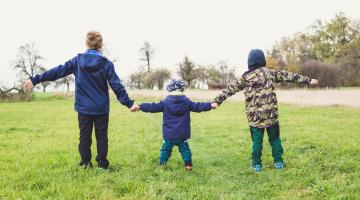 A picture of three children holding hands