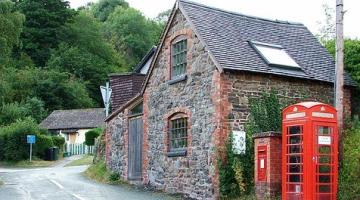 house with red phone box beside it