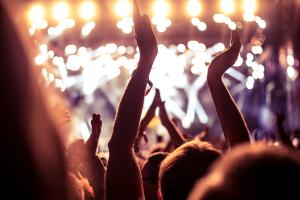 View towards stage of crowd with hands up at a festival 